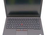the laptop is open on a white surface and has a red button on the keyboard