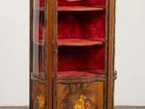 une vieille armoire en bois ornée de velours rouge et de décorations dorées