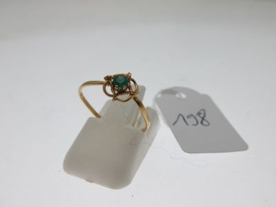 an image of a gold ring with a green stone on it