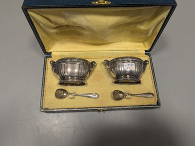 deux assiettes et cuillères en métal argenté dans un coffret bleu