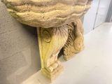 a stone bird that is sitting on top of a pedestal