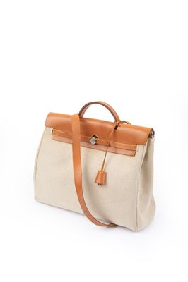 Le petit sac beige et marron clair est posé sur une surface blanche.