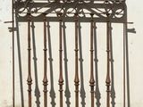 a metal fence that is standing in front of a white wall