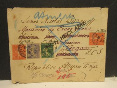 une vieille carte postale couverte de timbres, posée sur une table