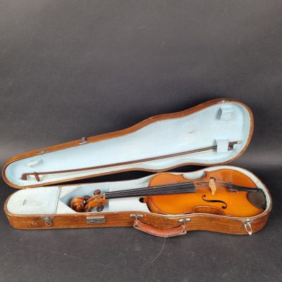 un vieil étui à violon contenant un violon, posé sur une table