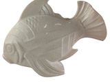 a white ceramic fish that is sitting on a table