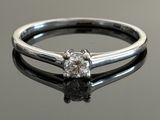 a close up of a diamond ring on a reflective surface