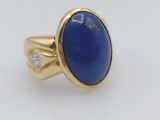 a close up of a gold ring with a lapis stone and a diamond
