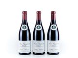 three bottles of red wine sitting next to each other on a white surface