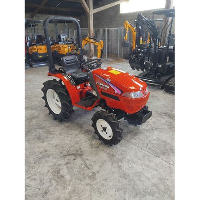 un tracteur rouge garé dans un entrepôt avec d'autres tracteurs