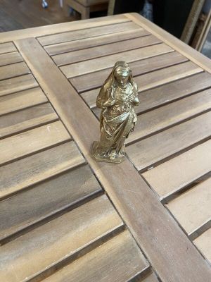 a gold figurine sitting on top of a wooden table