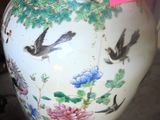 a white vase with birds and flowers painted on it