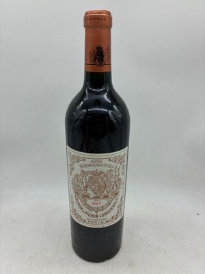 la bouteille de vin rouge est posée sur une surface blanche