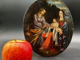 une assiette décorée d'une peinture, à côté d'une pomme