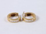 pair of gold and diamond hoop earrings on white background