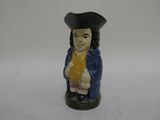 une figurine représentant un homme vêtu d'un manteau bleu et d'un chapeau