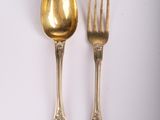 two spoons and a fork on a white surface