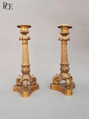 two gold candlesticks sitting on a table
