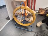 a black and white cat playing with a yellow and blue fan