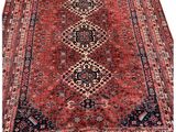 un tapis persan ancien aux motifs rouges et noirs