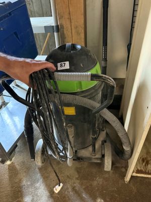 un homme qui tient un aspirateur à la main