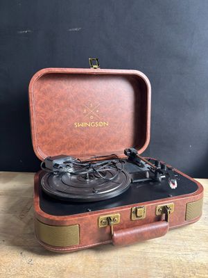 an old suitcase with a record player in it on a wooden table
