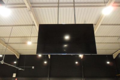 un grand écran fixé au plafond d'un immeuble