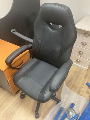une chaise de bureau noire posée à côté d'un bureau en bois