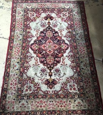 an oriental rug on the floor in a room with concrete flooring