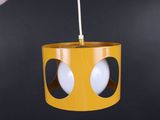 a yellow light hanging from a ceiling with two eyes on it
