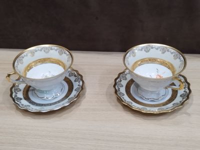 deux tasses et soucoupes sont posées sur une table en bois