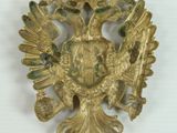 an image of a gold colored brooch with two birds on it