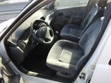 the interior of a small white car with the door open