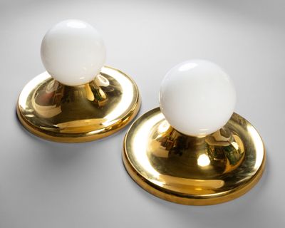 une paire de lampes de table en laiton et en verre blanc sur fond gris