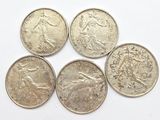 four silver coins sitting on top of each other on a white surface