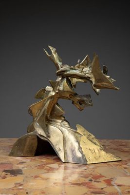 sculpture en bronze représentant une tête de dragon posée sur une table en marbre