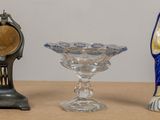 three glass vases and a clock sitting on a table