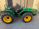 a picture of a green tractor parked in front of a building
