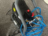 un tuyau bleu raccordé à un compresseur d'air gris et noir
