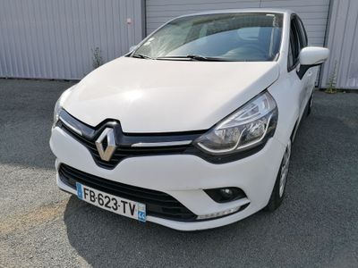 la voiture blanche est garée devant un bâtiment