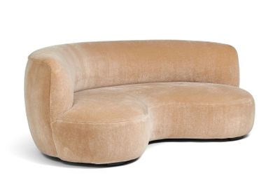 une photo d'un canapé incurvé beige avec un piètement noir