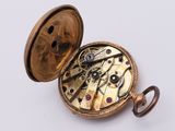 a pocket watch that is open on a white surface