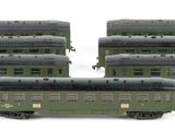 three green train cars sitting next to each other on a white surface