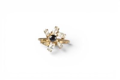 a close up of a gold ring with a black and white diamond