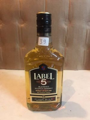 a bottle of alcohol sitting on a table next to a wall