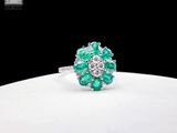 an image of a ring with emeralds and diamonds