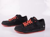 une paire de baskets noires et orange avec des lacets orange