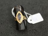 gros plan d'une bague sur une surface noire avec une étiquette de prix