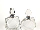 paire de flacons de parfum en cristal sur fond blanc, avec un espace réservé au texte