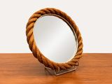 un miroir posé sur une table en bois, entouré d'une corde